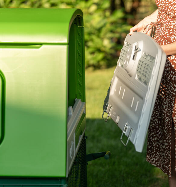 Donna che smonta il retro di un pollaio Eglu Cube 